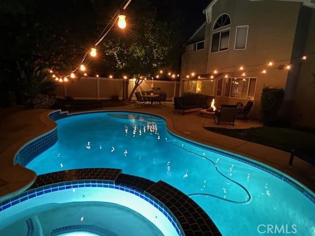 6730 Harrington Ct, Chino, CA 91710 - pool at night featuring a pool with connected hot tub and a patio area