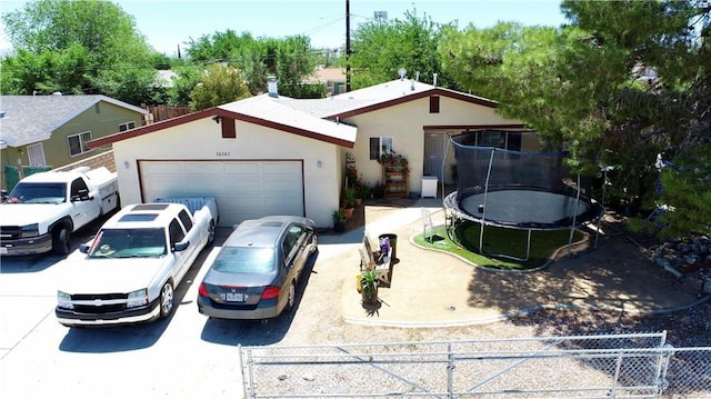 16161 Vallejo St, Victorville, CA 92395 - single story home featuring a trampoline, fence, driveway, stucco siding, and a garage