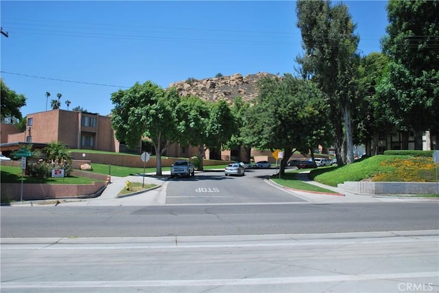 4676 Maxwell Ct, Riverside, CA 92501 - view of asphalt road featuring traffic signs, curbs, and sidewalks