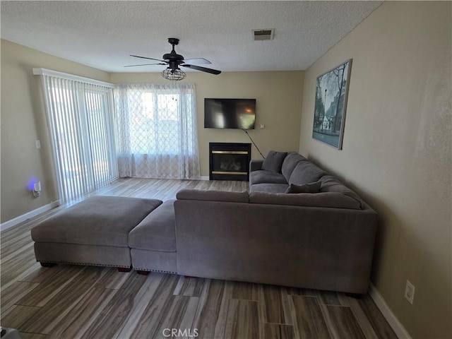 4676 Maxwell Ct, Riverside, CA 92501 - living area with wood finished floors, ceiling fan, a textured ceiling, and a glass covered fireplace