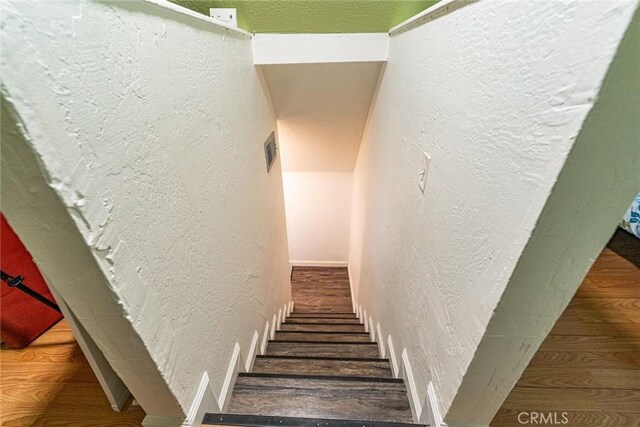 23120 Sycamore Ln, Crestline, CA 92325 - staircase with a textured wall, wood finished floors, and baseboards