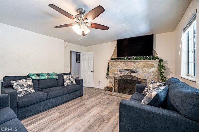 23120 Sycamore Ln, Crestline, CA 92325 - living area featuring wood finished floors, a ceiling fan, a fireplace, and baseboards
