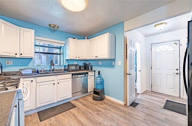 23120 Sycamore Ln, Crestline, CA 92325 - kitchen featuring stainless steel dishwasher, a sink, light wood finished floors, baseboards, and white cabinetry