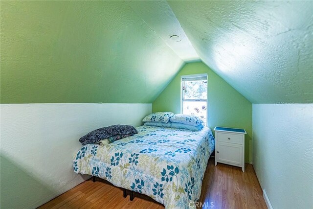 23120 Sycamore Ln, Crestline, CA 92325 - bedroom with wood finished floors, vaulted ceiling, baseboards, and a textured ceiling