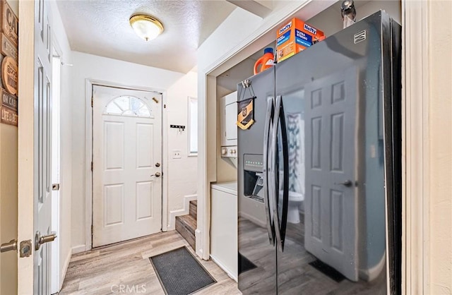23120 Sycamore Ln, Crestline, CA 92325 - entryway with stacked washer and clothes dryer and light wood-style flooring