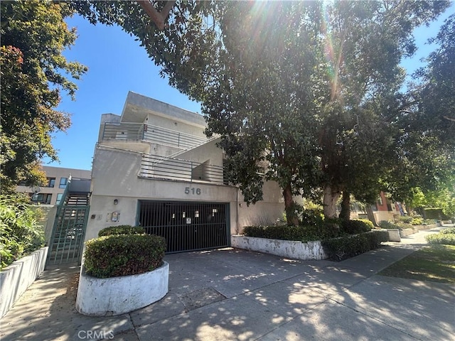 516 Venice Way, Inglewood, CA 90302 - view of front of house featuring concrete driveway, a garage, a balcony, and stucco siding