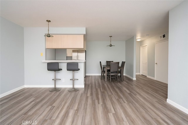 516 Venice Way, Inglewood, CA 90302 - kitchen with a breakfast bar area, light wood-style floors, a peninsula, and light countertops
