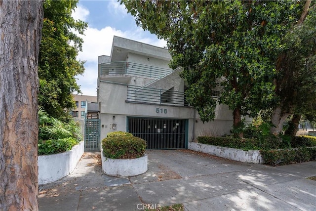 516 Venice Way, Inglewood, CA 90302 - art deco house featuring a balcony, concrete driveway, a gate, and a garage
