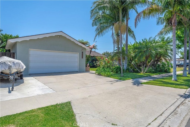 8922 Tracy Ave, Garden Grove, CA 92841 - view of front of house featuring stucco siding, driveway, an attached garage, and a front lawn