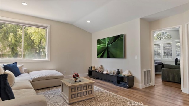 living area featuring wood finished floors, recessed lighting, baseboards, and vaulted ceiling