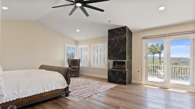 bedroom with access to outside, multiple windows, lofted ceiling, wood finished floors, and recessed lighting