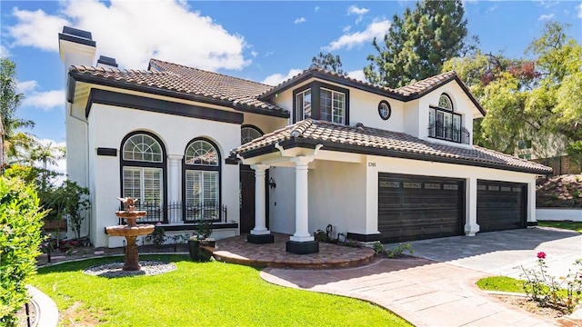 mediterranean / spanish-style home with a garage, concrete driveway, a tiled roof, and a chimney