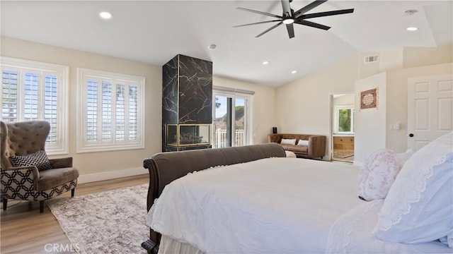 bedroom featuring access to outside, multiple windows, light wood-style floors, lofted ceiling, and recessed lighting