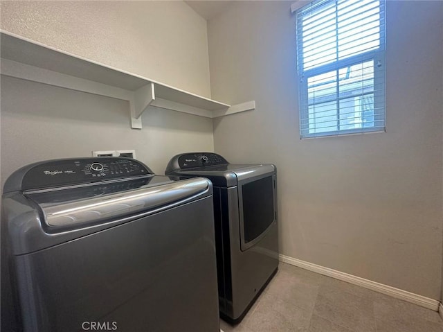 washroom featuring independent washer and dryer, plenty of natural light, baseboards, and light tile patterned flooring