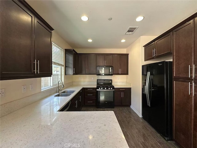 kitchen with black appliances, a sink, dark brown cabinetry, recessed lighting, and dark wood-style floors