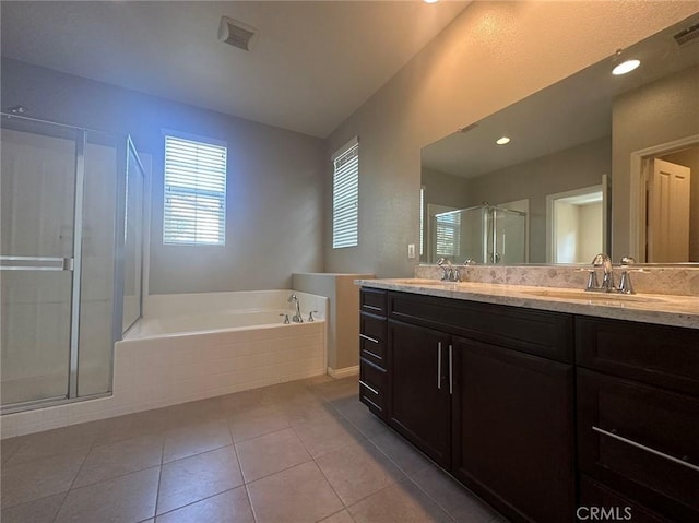 bathroom featuring healthy amount of natural light, a bath, a shower stall, and double vanity