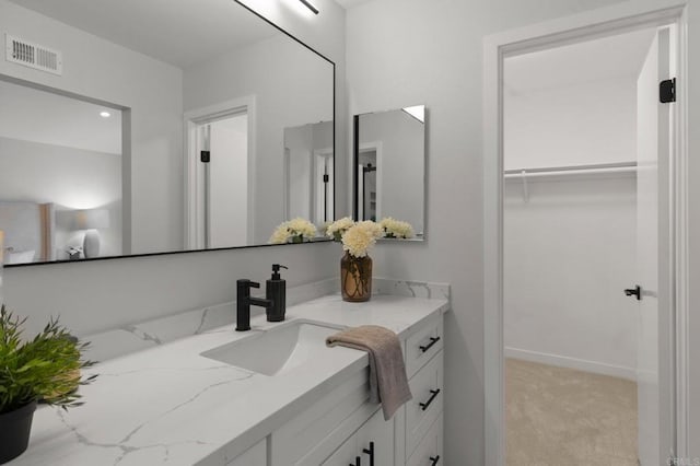 bathroom featuring vanity and a walk in closet