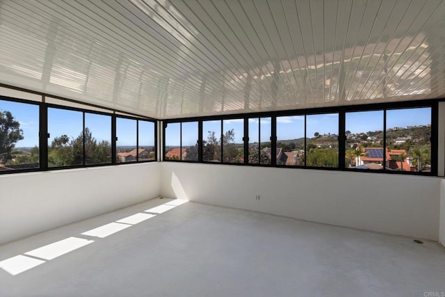 unfurnished sunroom featuring healthy amount of natural light and concrete floors