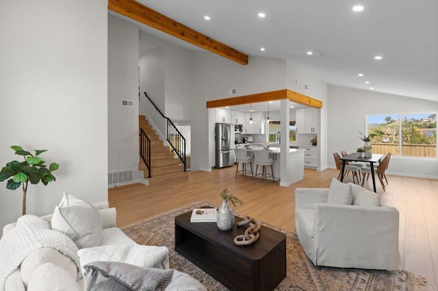 living area with recessed lighting, light wood finished floors, stairs, and baseboards