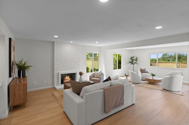 9142 Ellingham St, San Diego, CA 92129 - living room with light wood finished floors, a brick fireplace, recessed lighting, and baseboards