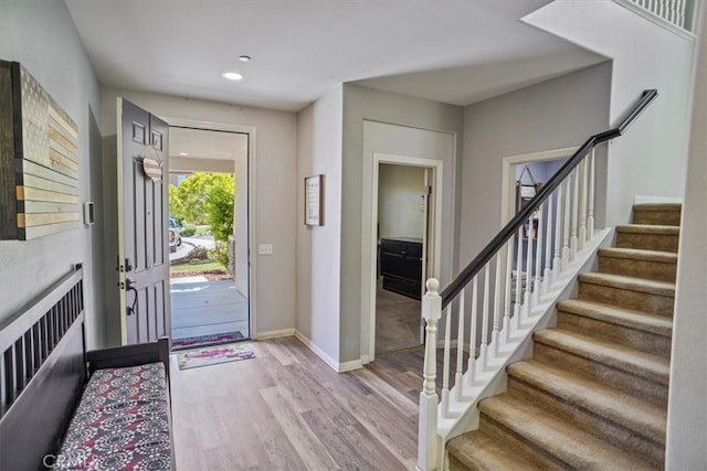 foyer entrance with wood finished floors, stairs, recessed lighting, and baseboards