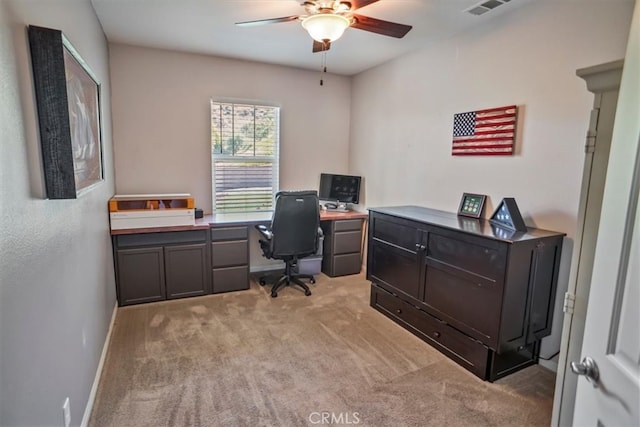 office area featuring ceiling fan, light carpet, and baseboards