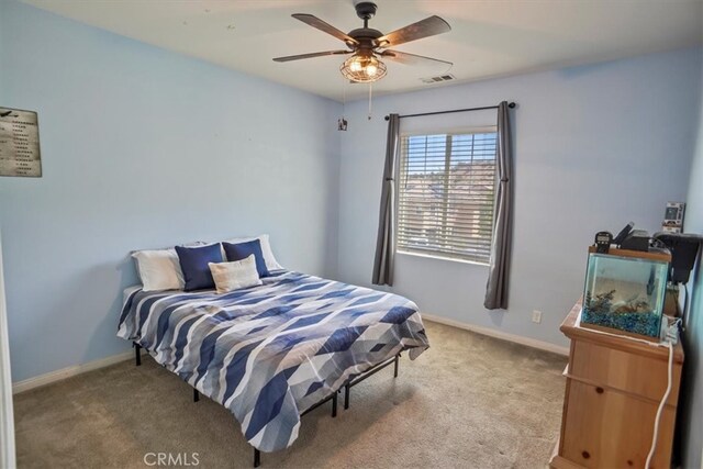 bedroom featuring light colored carpet, baseboards, and ceiling fan