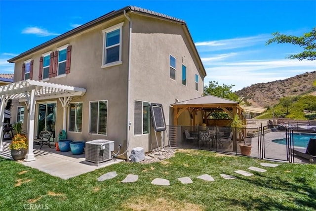 back of property with a gazebo, a pergola, stucco siding, and a patio