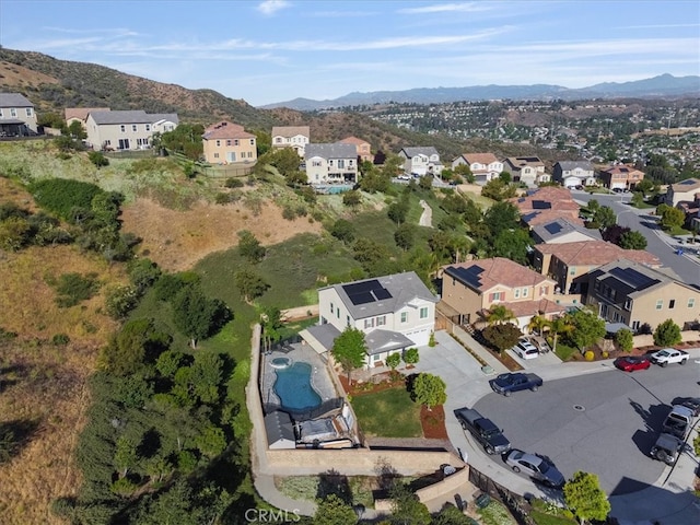 view of property location featuring a mountainous background, nearby suburban area, and a pool