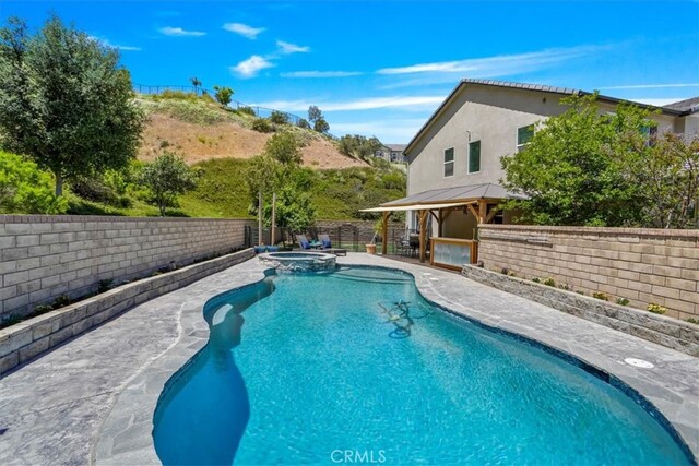 view of pool featuring a fenced backyard, a patio, a gazebo, and a pool with connected hot tub