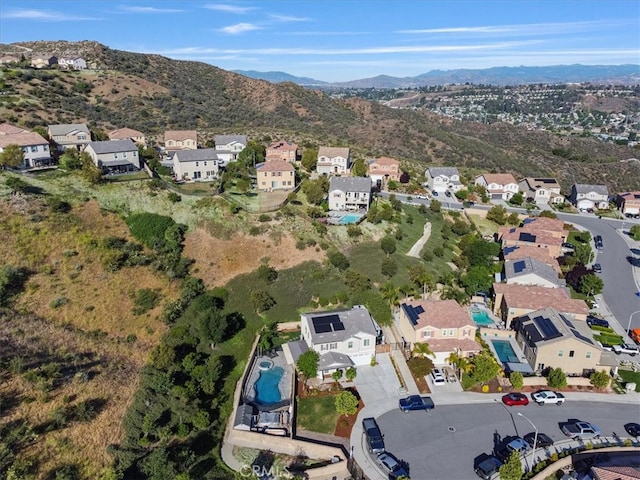 aerial view of property's location with nearby suburban area and a mountain backdrop