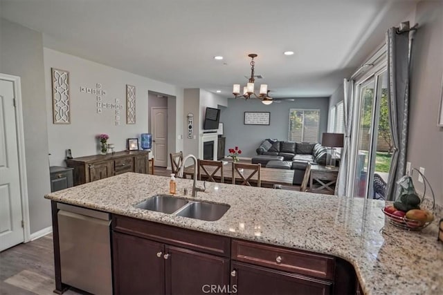 kitchen featuring a sink, stainless steel dishwasher, a chandelier, decorative light fixtures, and wood finished floors