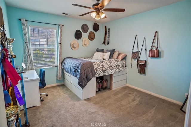 bedroom featuring carpet flooring, an office area, a ceiling fan, and baseboards