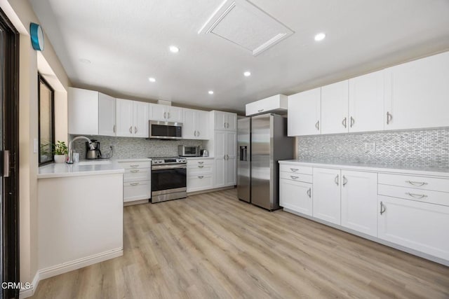 286 W Montecito Ave Unit K, Sierra Madre, CA 91024 - kitchen with stainless steel appliances, a sink, decorative backsplash, light wood-style floors, and white cabinetry