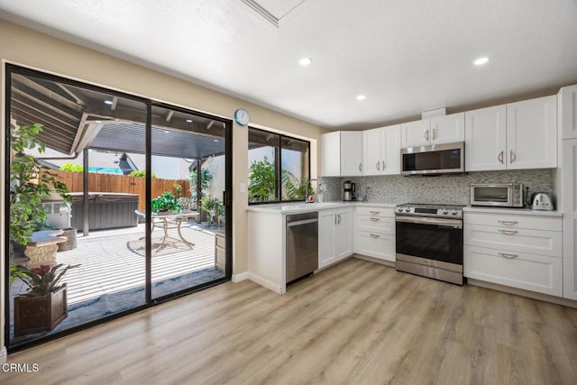 286 W Montecito Ave Unit K, Sierra Madre, CA 91024 - kitchen featuring stainless steel appliances, decorative backsplash, light wood finished floors, white cabinetry, and recessed lighting