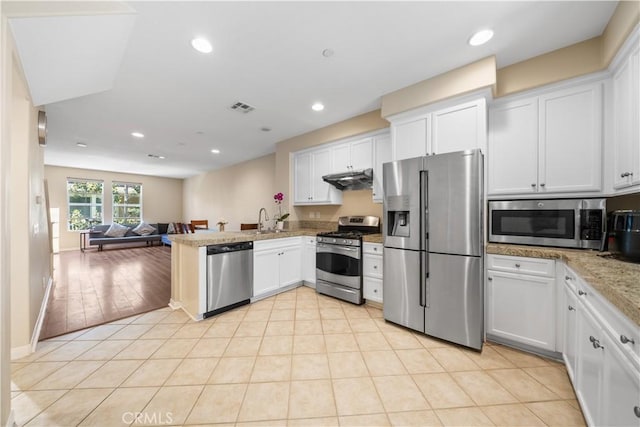 414 Silk Tree, Irvine, CA 92606 - kitchen with stainless steel appliances, open floor plan, white cabinetry, under cabinet range hood, and recessed lighting