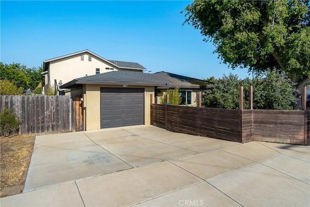 1599 21st St, Oceano, CA 93445 - view of front of home with stucco siding, an attached garage, driveway, fence, and roof with shingles