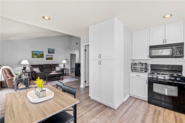 20155 Keaton St, Canyon Country, CA 91351 - kitchen featuring black appliances, white cabinets, open floor plan, light wood-style flooring, and recessed lighting