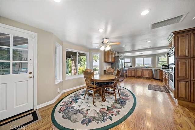 dining space with light wood-style floors, ceiling fan, baseboards, and recessed lighting