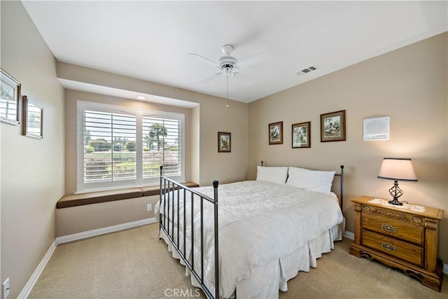 bedroom with light carpet, baseboards, and a ceiling fan