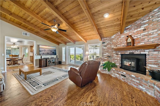 living room featuring wood finished floors, wooden ceiling, ceiling fan, beam ceiling, and healthy amount of natural light