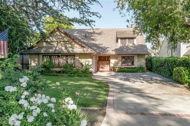 1558 Hillcrest Ave, Glendale, CA 91202 - tudor home featuring concrete driveway, stucco siding, an attached garage, and a front yard