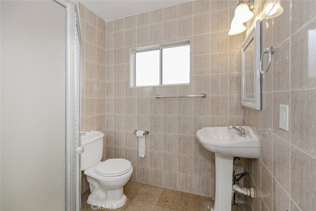 7857 Whitsett Ave, North Hollywood, CA 91605 - bathroom with a sink, tile walls, toilet, and a stall shower