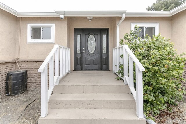 7857 Whitsett Ave, North Hollywood, CA 91605 - doorway to property with stucco siding, a security system, central AC, and a porch