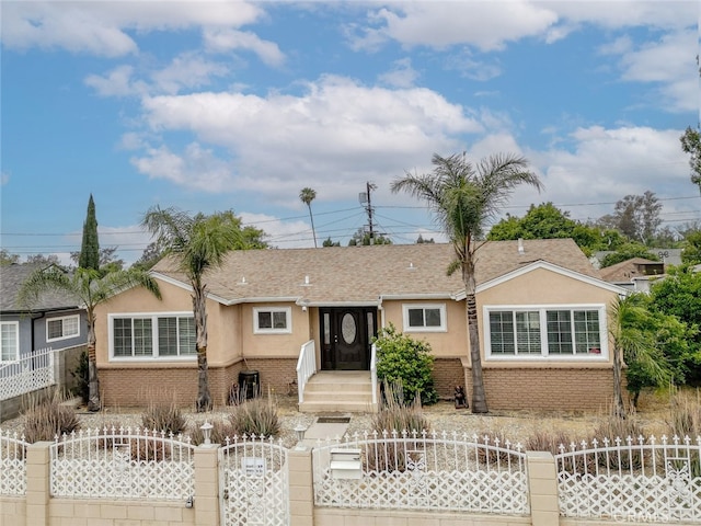 7857 Whitsett Ave, North Hollywood, CA 91605 - ranch-style house with stucco siding, a fenced front yard, a gate, and brick siding