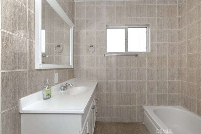 7857 Whitsett Ave, North Hollywood, CA 91605 - bathroom featuring tile walls, vanity, and a tub to relax in