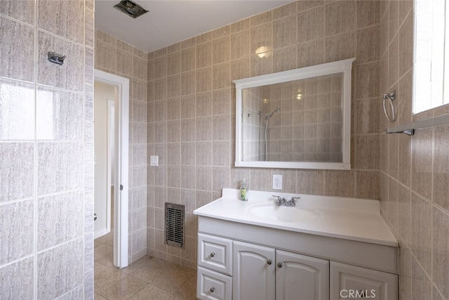 7857 Whitsett Ave, North Hollywood, CA 91605 - bathroom with tile walls, vanity, and tile patterned flooring
