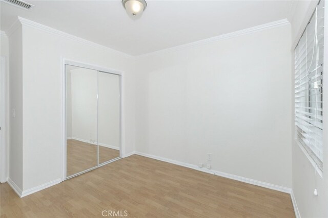 7857 Whitsett Ave, North Hollywood, CA 91605 - unfurnished bedroom with light wood-style floors, ornamental molding, a closet, and baseboards