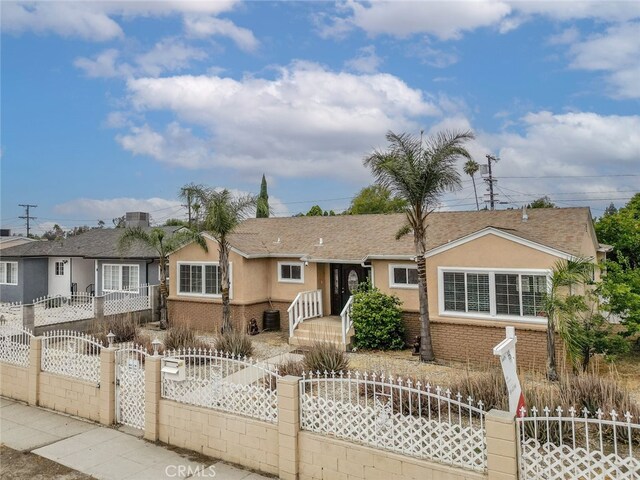 7857 Whitsett Ave, North Hollywood, CA 91605 - ranch-style house with stucco siding, a fenced front yard, a gate, and brick siding