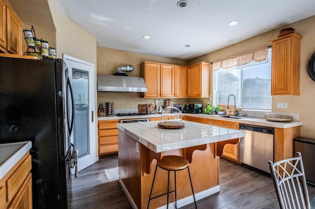 3035 Cat Tail Ct, Hemet, CA 92545 - kitchen with stainless steel dishwasher, freestanding refrigerator, range hood, tile counters, and a center island